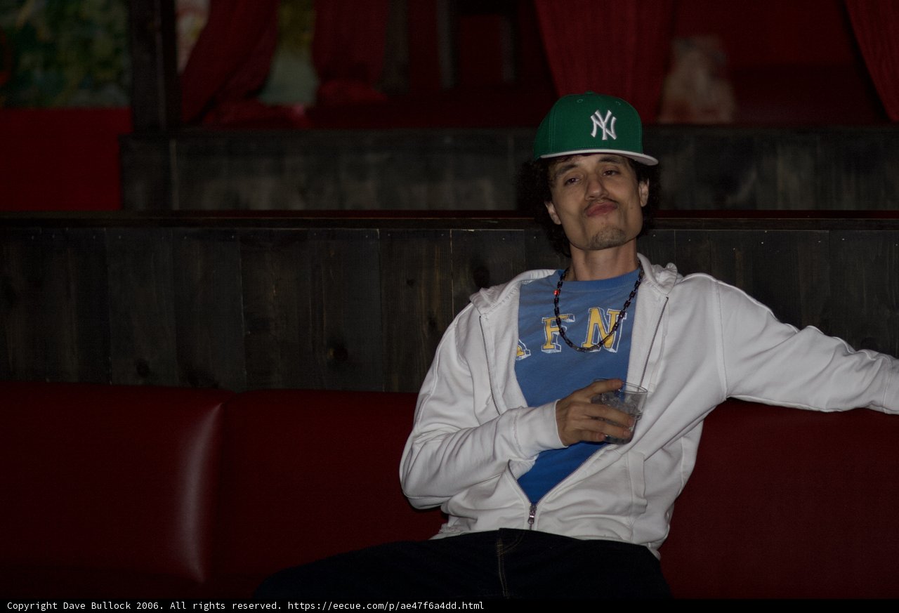 Man in a Baseball Cap Sitting on Red Couch
