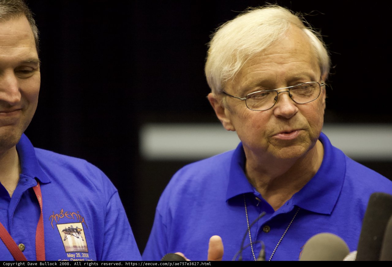 Conversation between two men in blue shirts