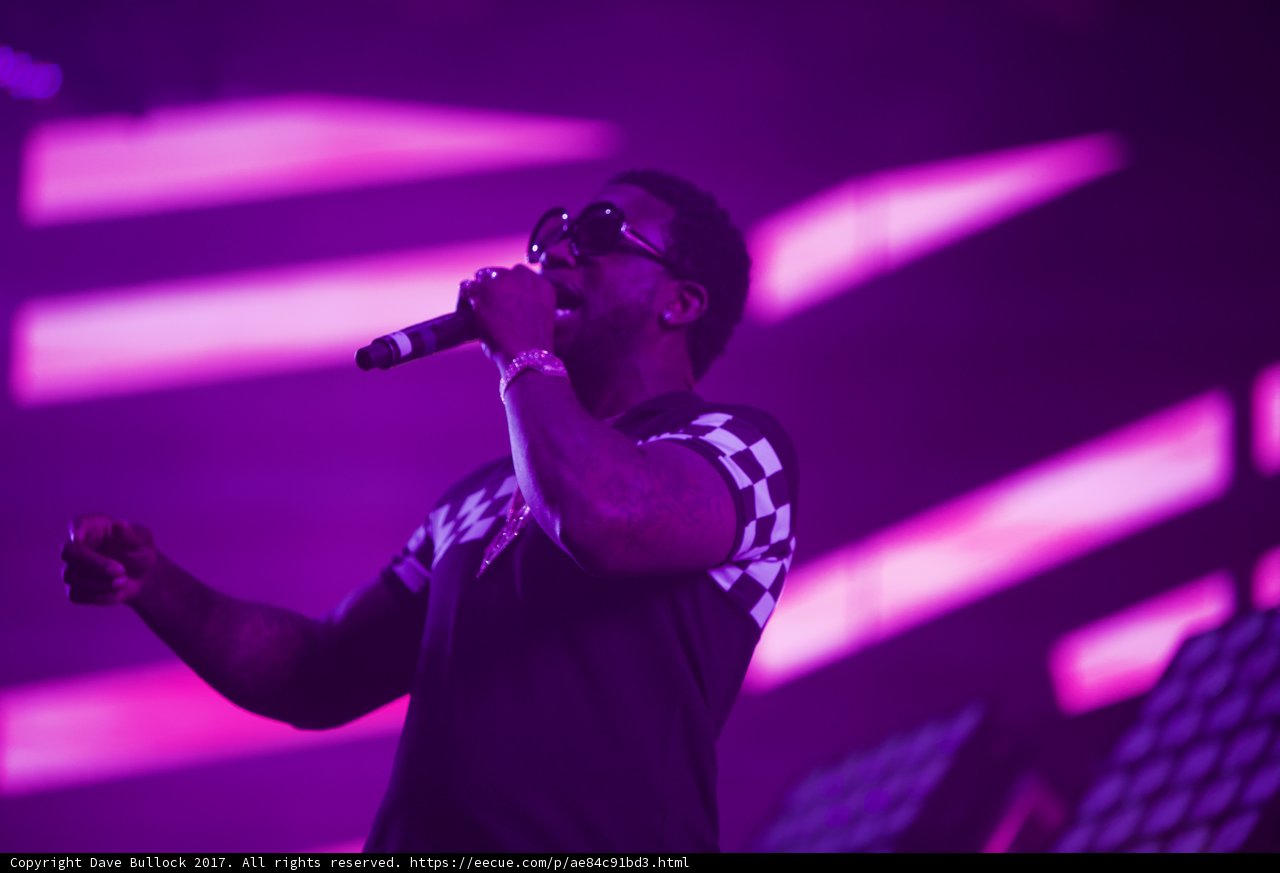 Rocking the Crowd Caption: An entertainer in sunglasses and a black shirt electrifies the audience with his solo performance at Coachella 2017.