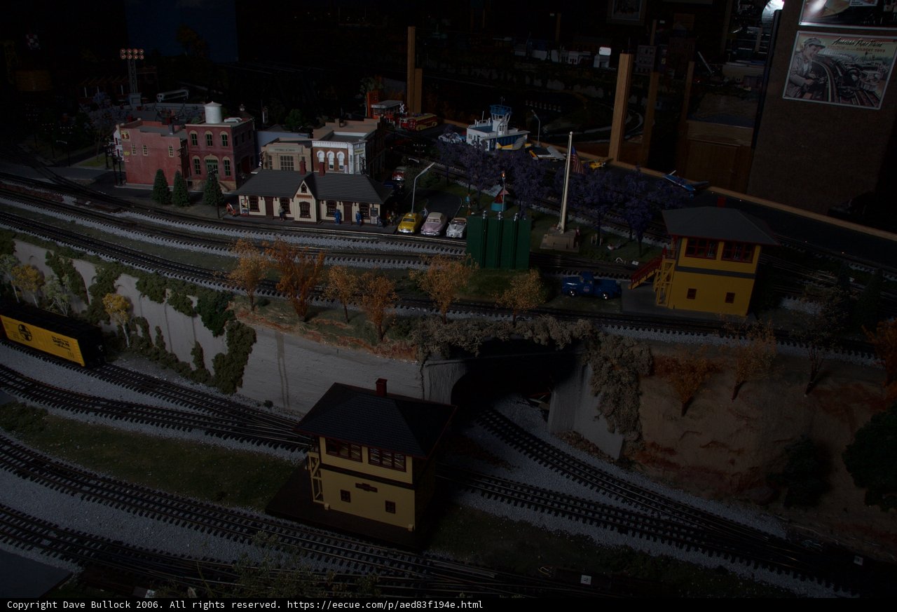 A Diorama of a Train Station with a Miniature Train Moving Along the Tracks