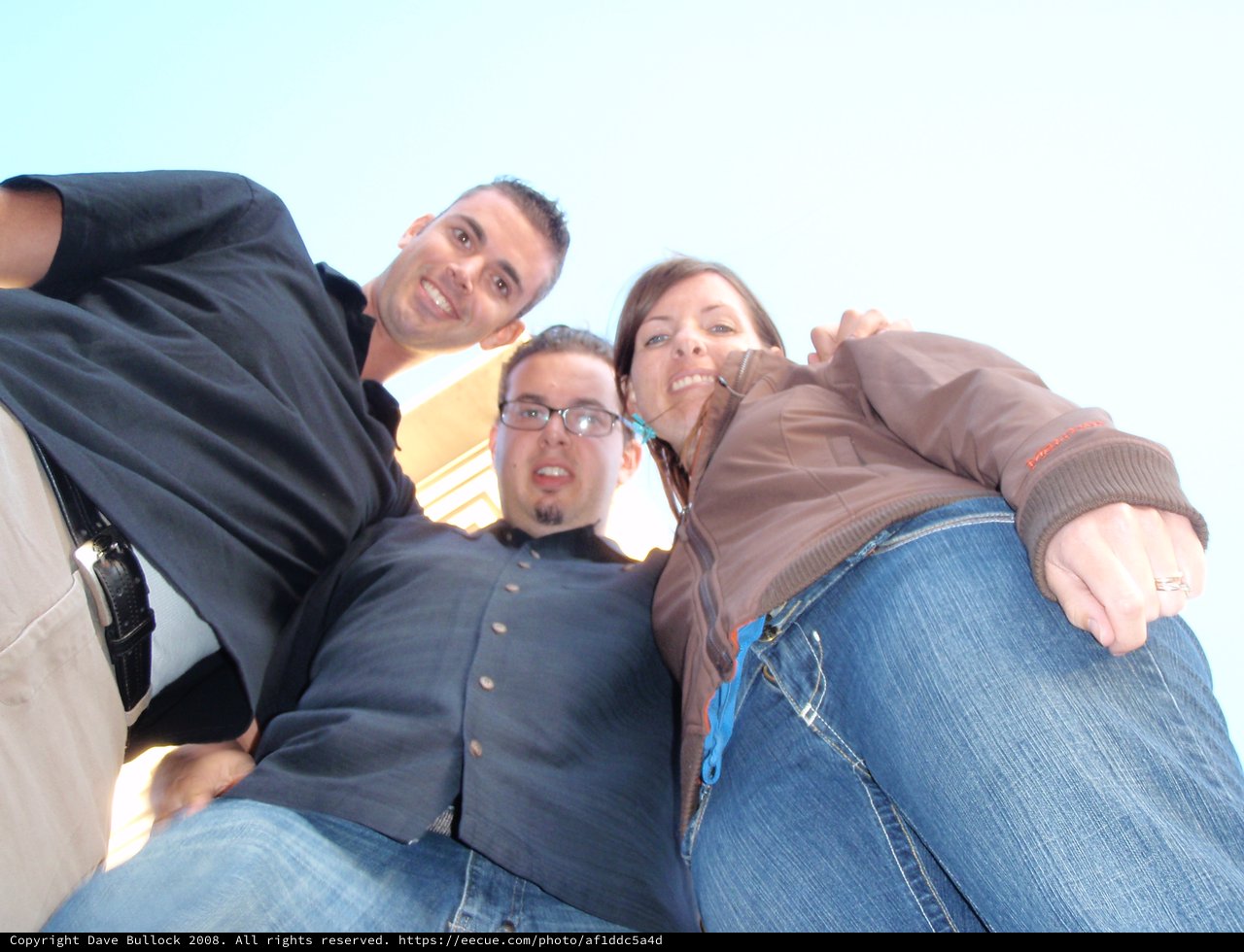 Three Friends Grinning Down at a Worm's-Eye Camera