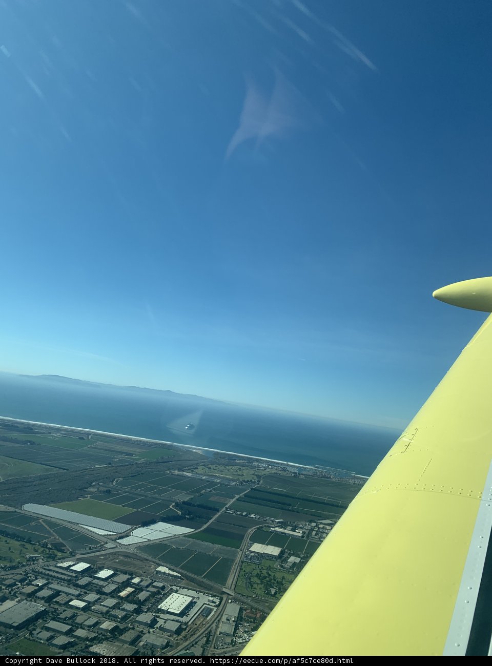A Bird's Eye View Caption: Enjoying the azure sky and stunning cityscape from the wing of a small airplane in 2018.
