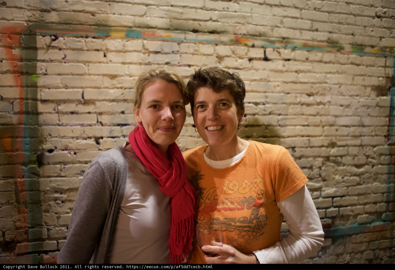 Two Women in Front of a Brick Wall