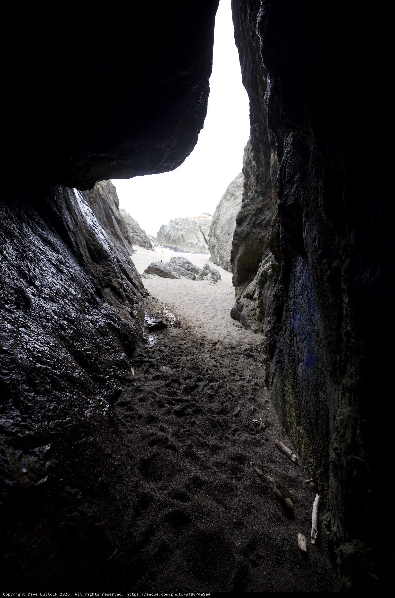 Through the Cave: Sandy Beach Beyond Dark Rocks
