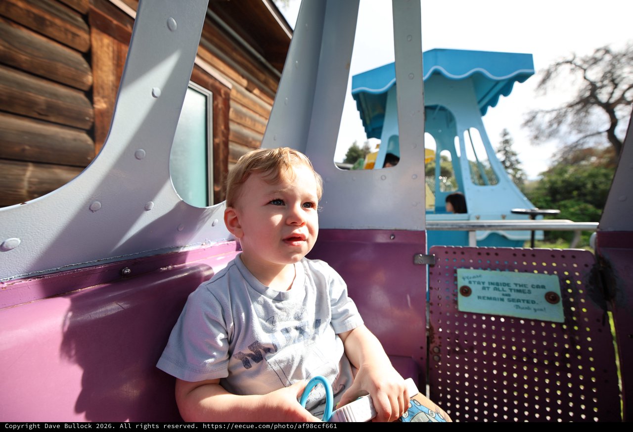 Young Child Enjoying Amusement Park Ride in Fantasyland