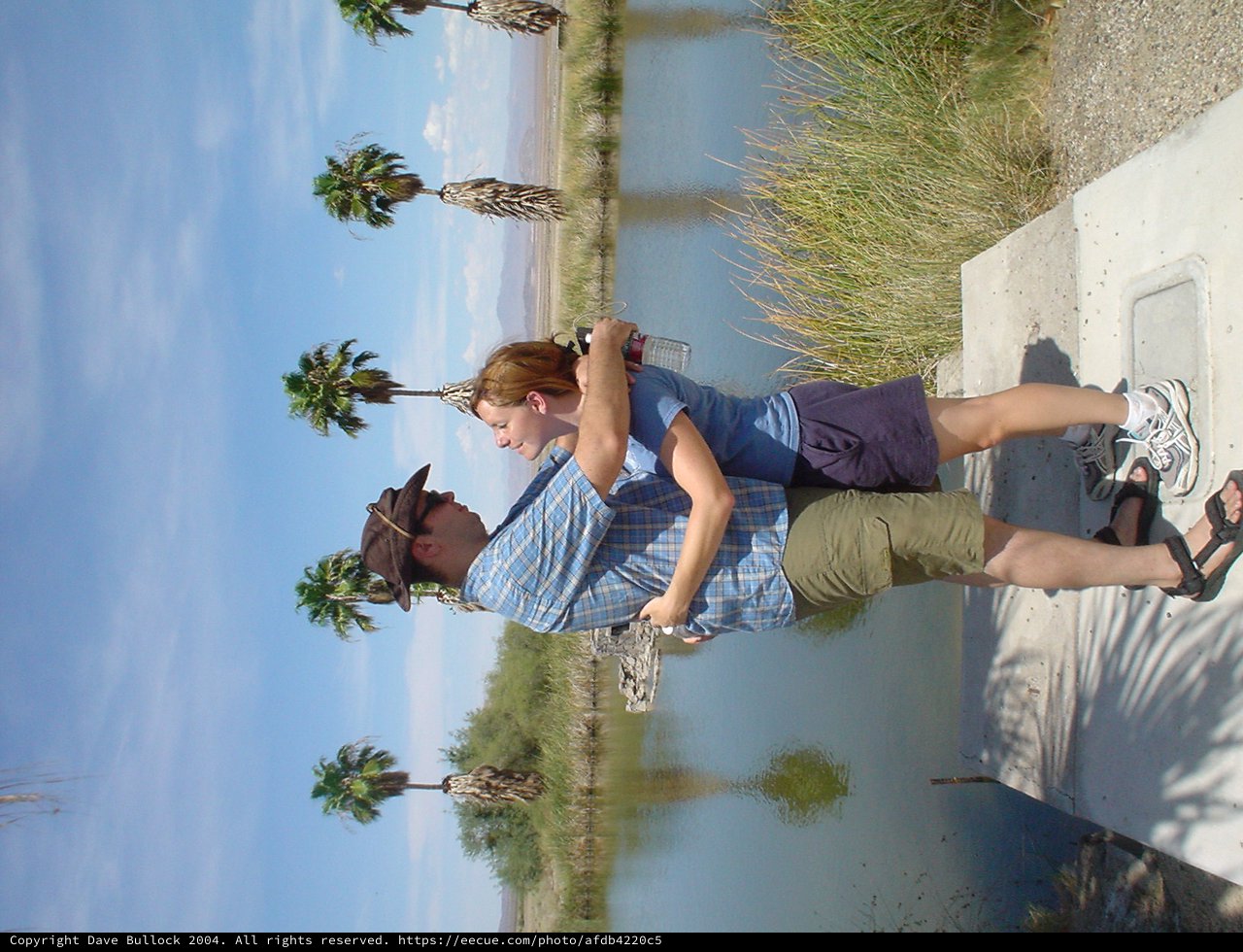 Couple Playfully Embracing by Desert Waterway