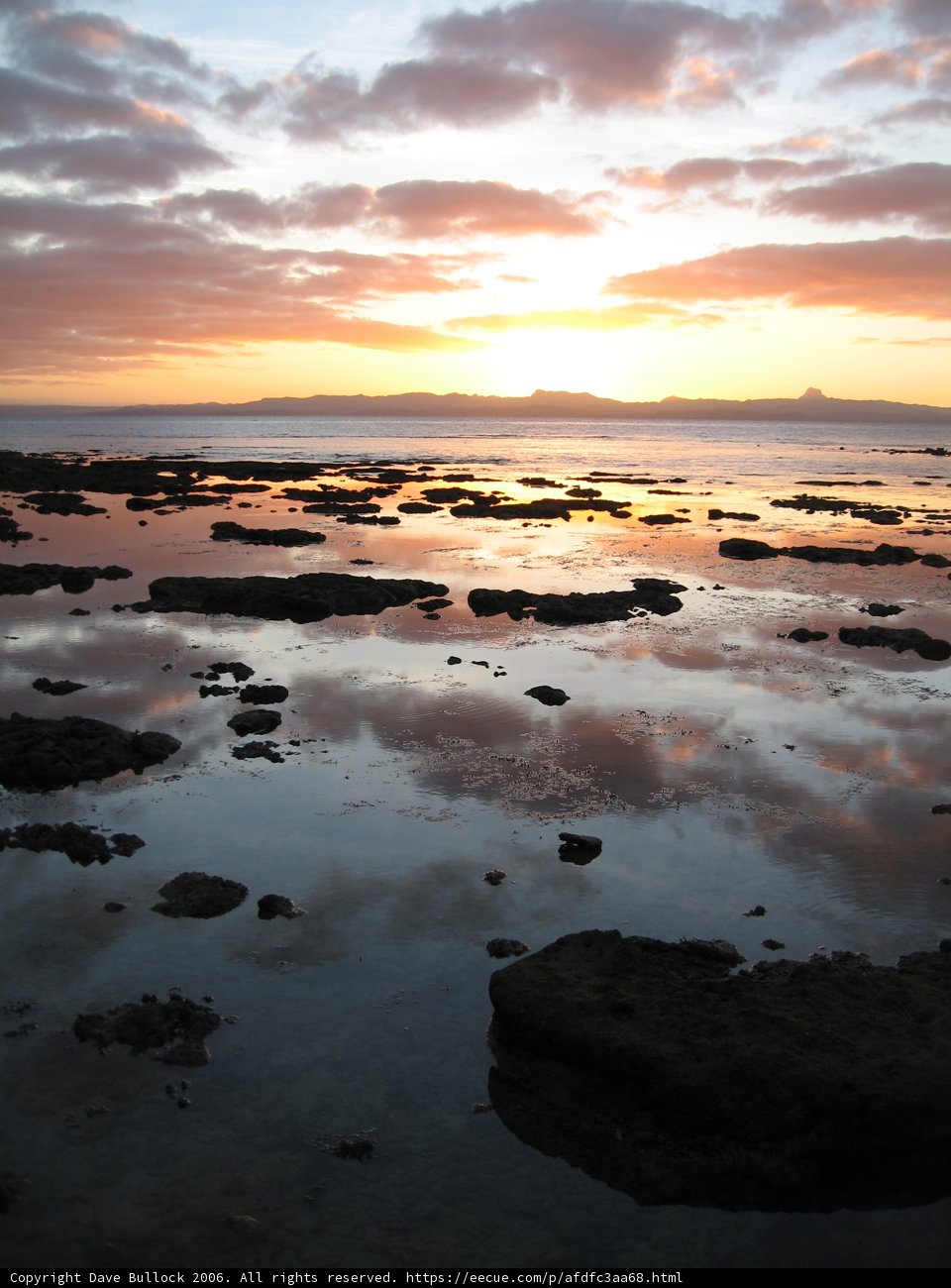 Fiery Sunset Reflections on Rocky Shores