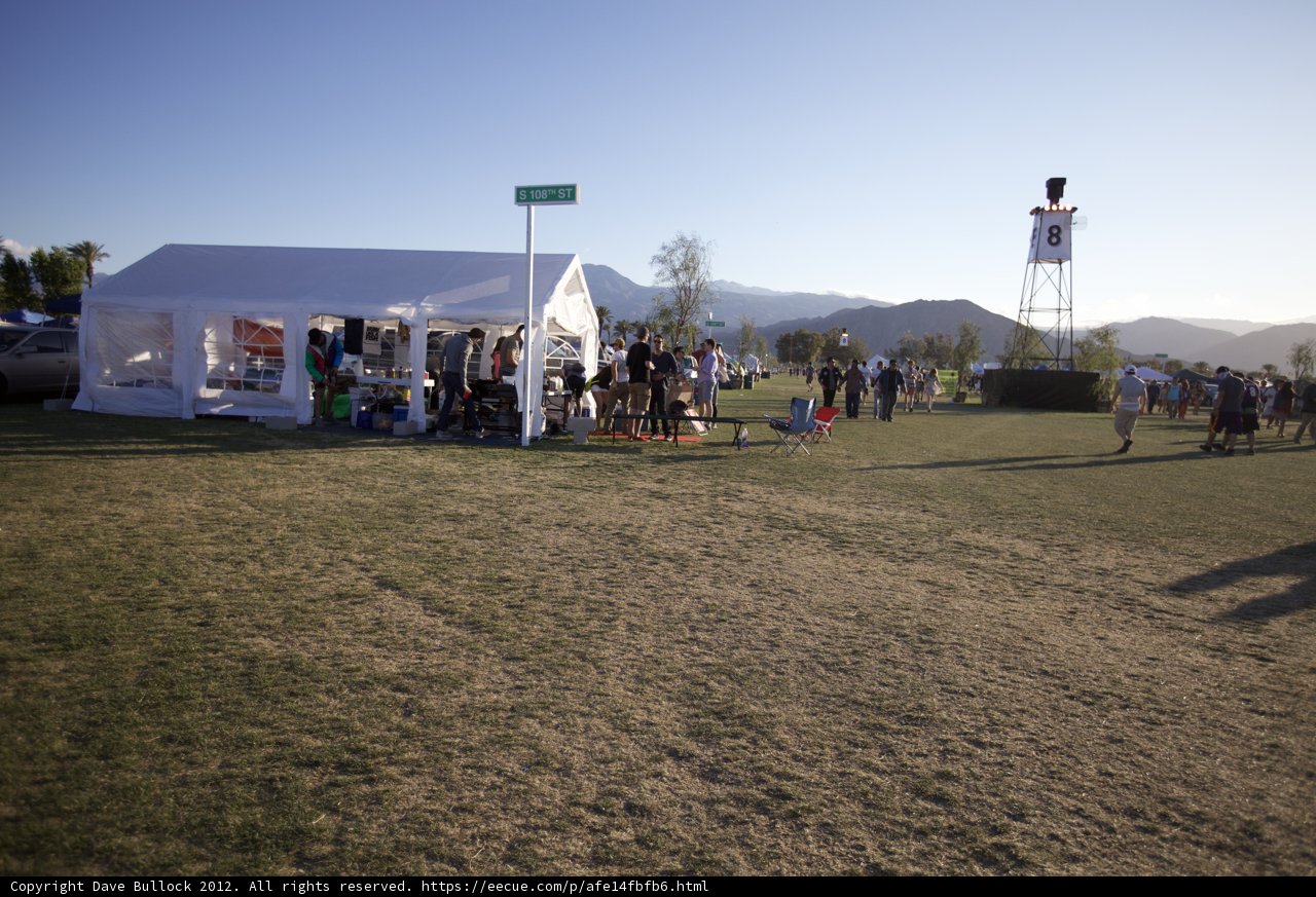 The Coachella 2012 Crowd Gathers in a Field with Blue Skies