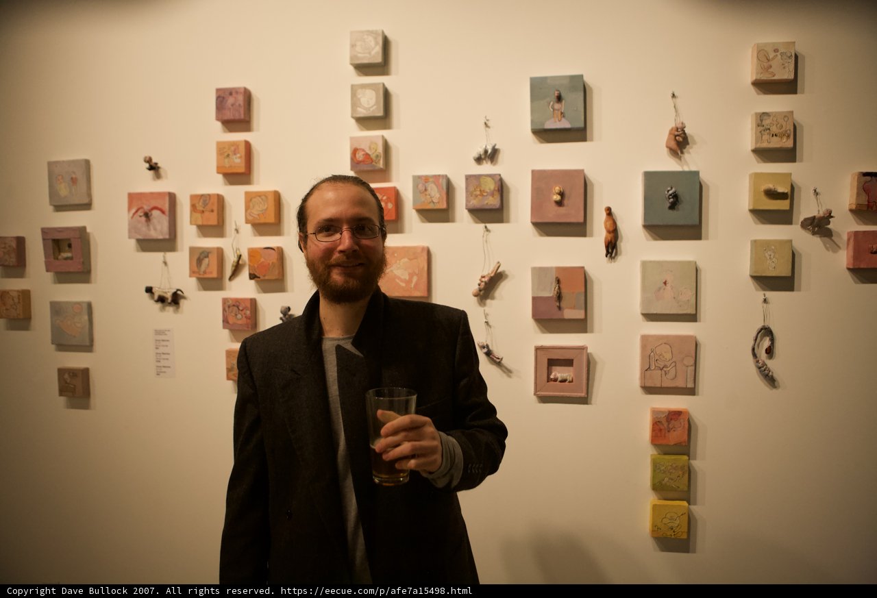 Man in Formal Wear Standing in Front of Wall of Art