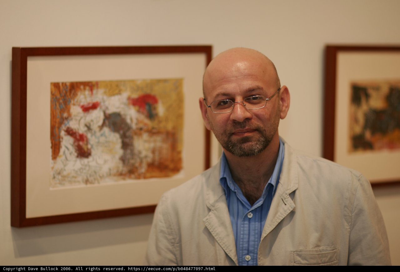 Bald Man Contemplates Two Paintings in Art Gallery