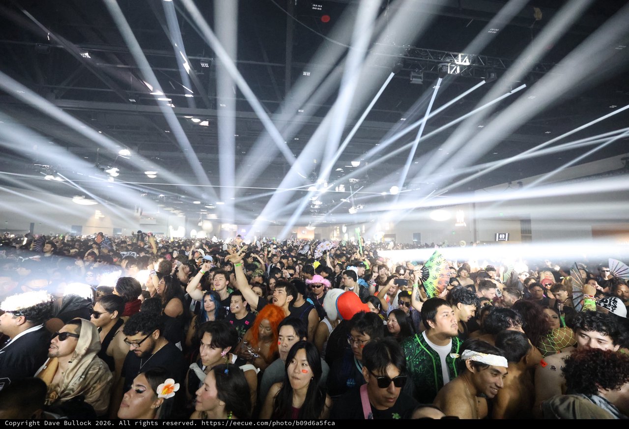 Massive Indoor Rave Crowd Bathed in Laser Beams