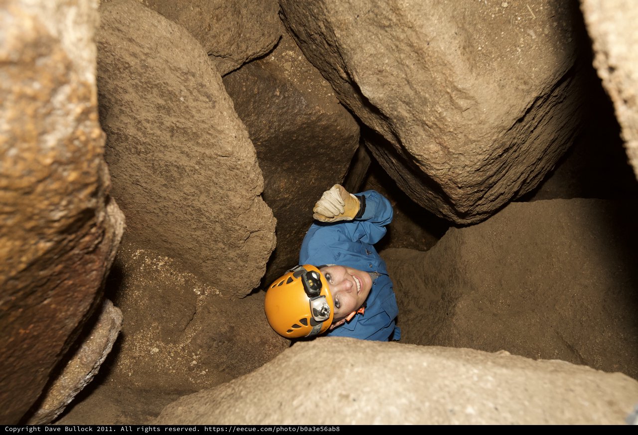 Caver Squeezes Through Tight Rocky Passage Underground