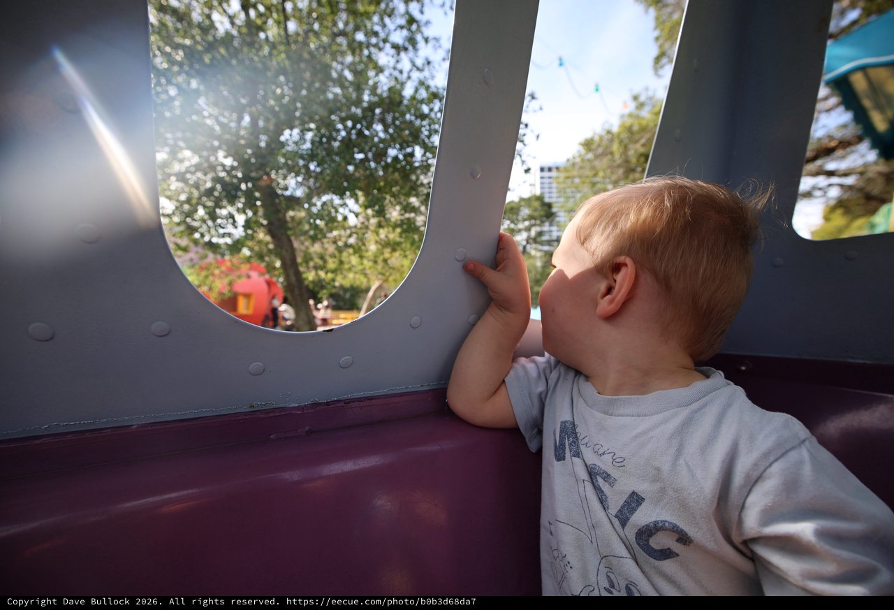 Child Gazing Through Playground Structure Window