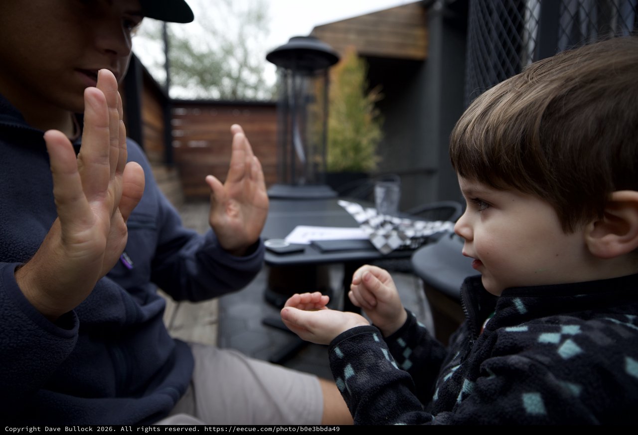 Father and Children Playing Hand Counting Game Outdoors