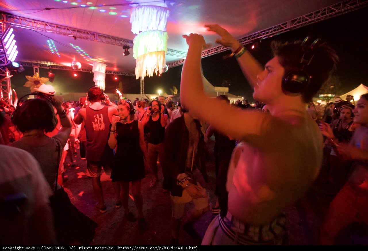 Shirtless Partygoer Dancing in Club Spotlight
