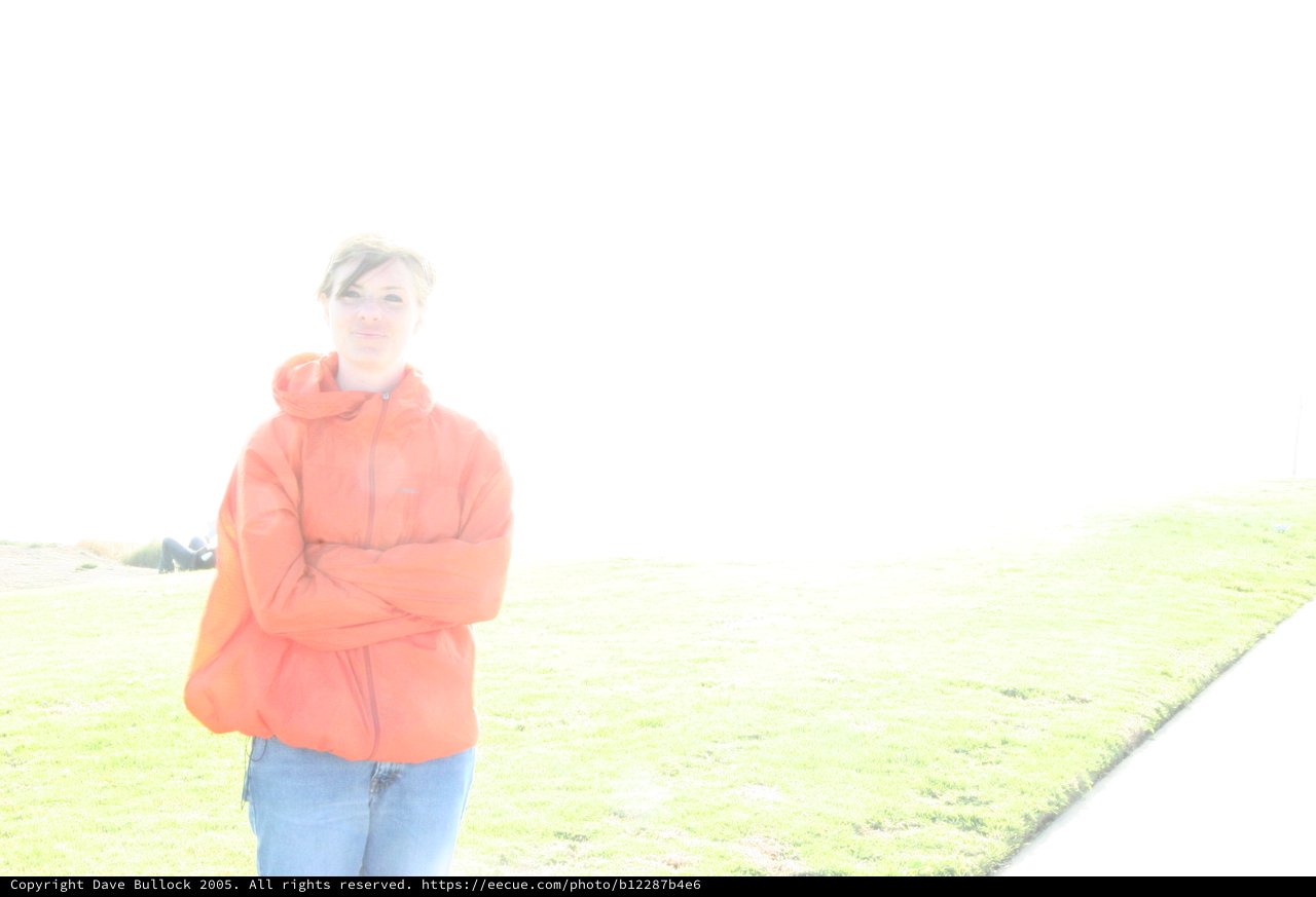 Overexposed Portrait of Woman in Orange Jacket Outdoors