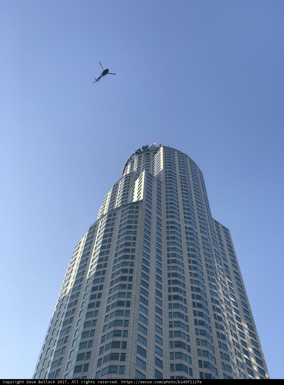Helicopter Flying Above Highrise Building in Urban Metropolis