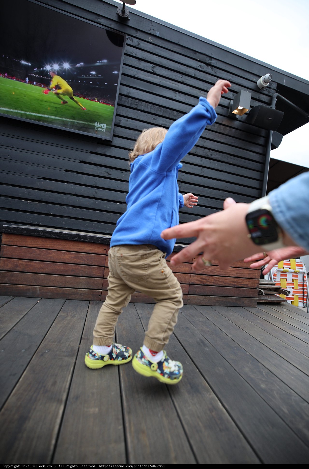 Child Celebrating Soccer Goal on Outdoor Deck