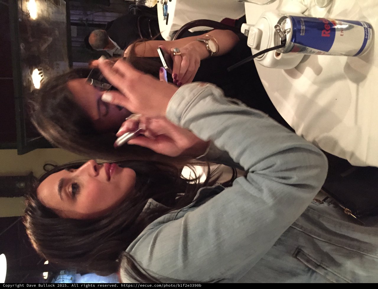 Two Women Applying Makeup at Restaurant Table