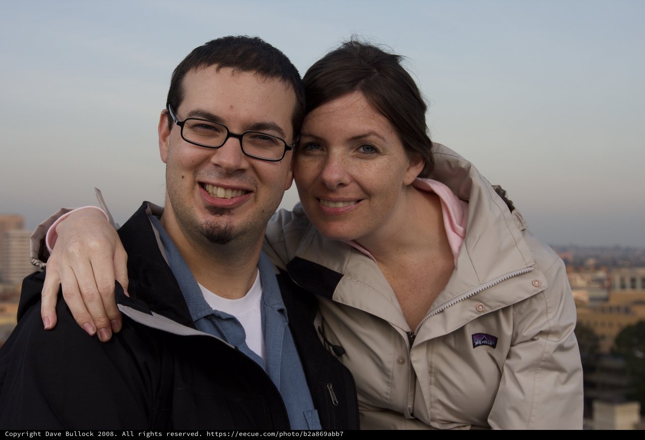 Smiling Couple Embracing Against City Skyline