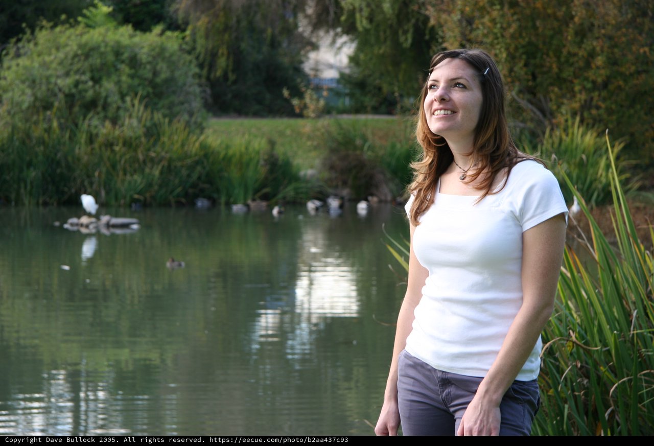 Smiling Woman by a Tranquil Park Pond