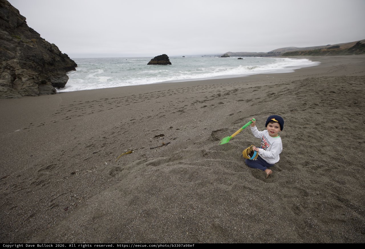 Young Child Playing in Sand at Rocky Coastline