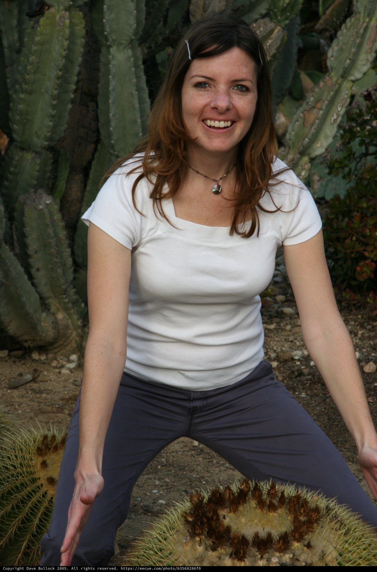 Smiling Woman Poses Among Desert Cacti Outdoors