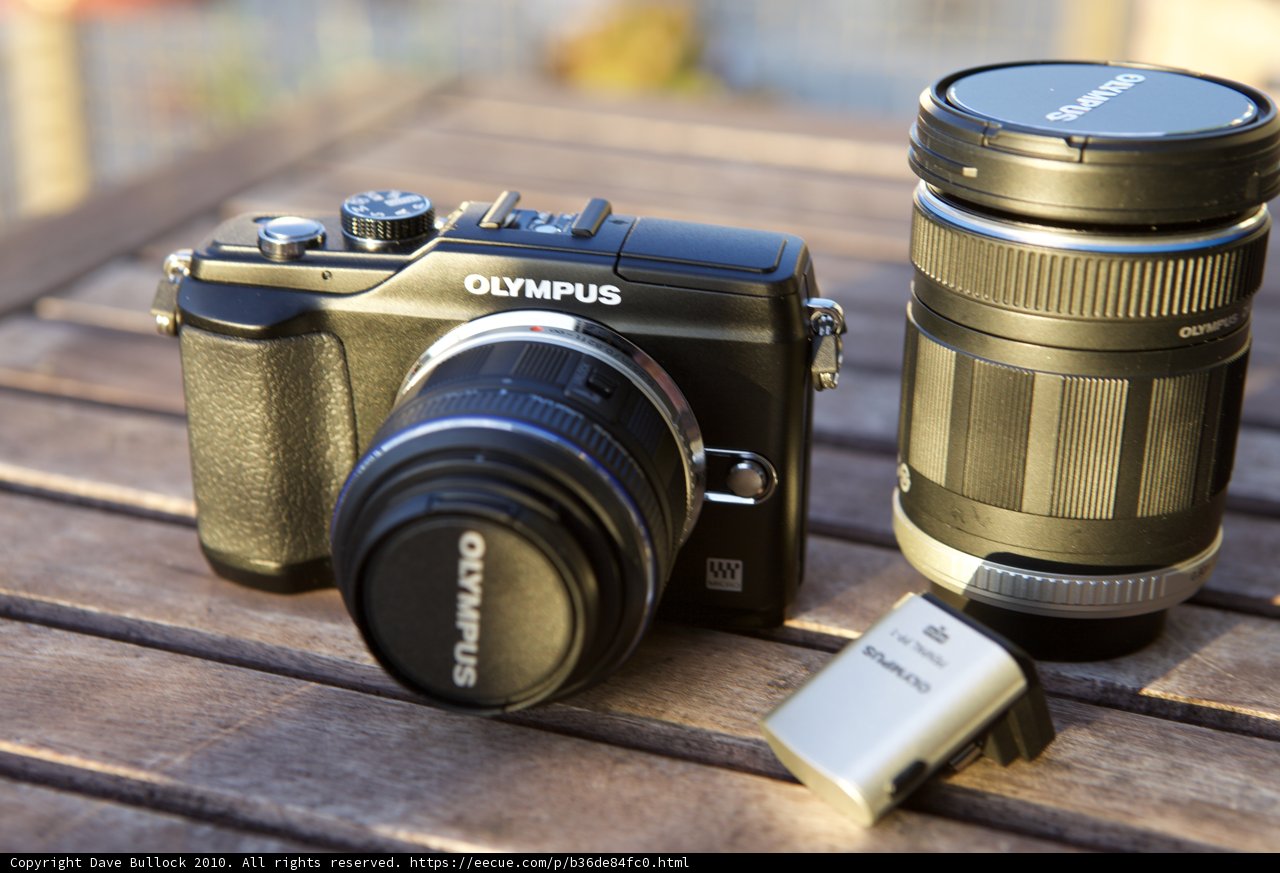 Camera and Lens on Wooden Table