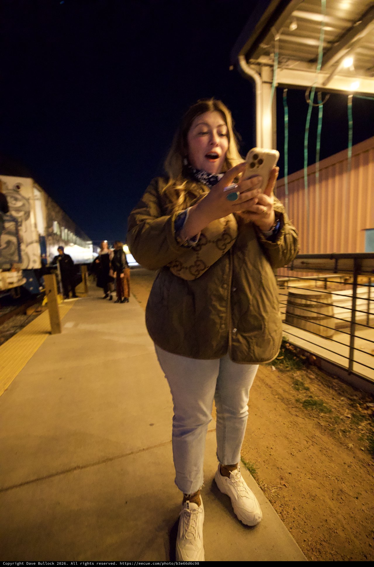 Late Night Phone Check at Train Platform