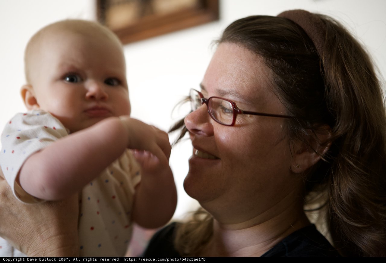 Joyful Mother Smiling at Curious Baby