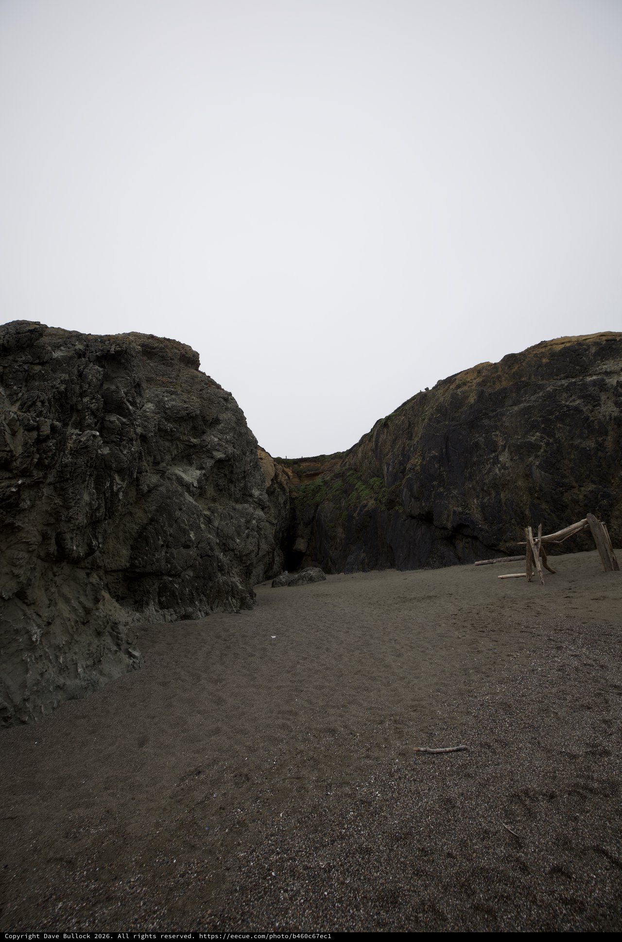 Dark Volcanic Cliffs Frame a Moody Coastal Cove