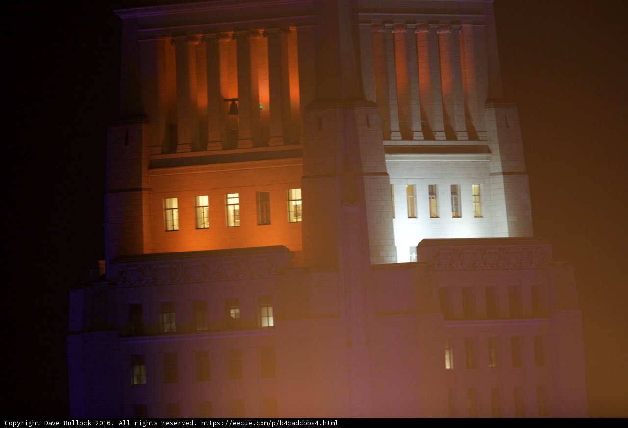 Illuminated Monastery Building with Clock Tower at Night