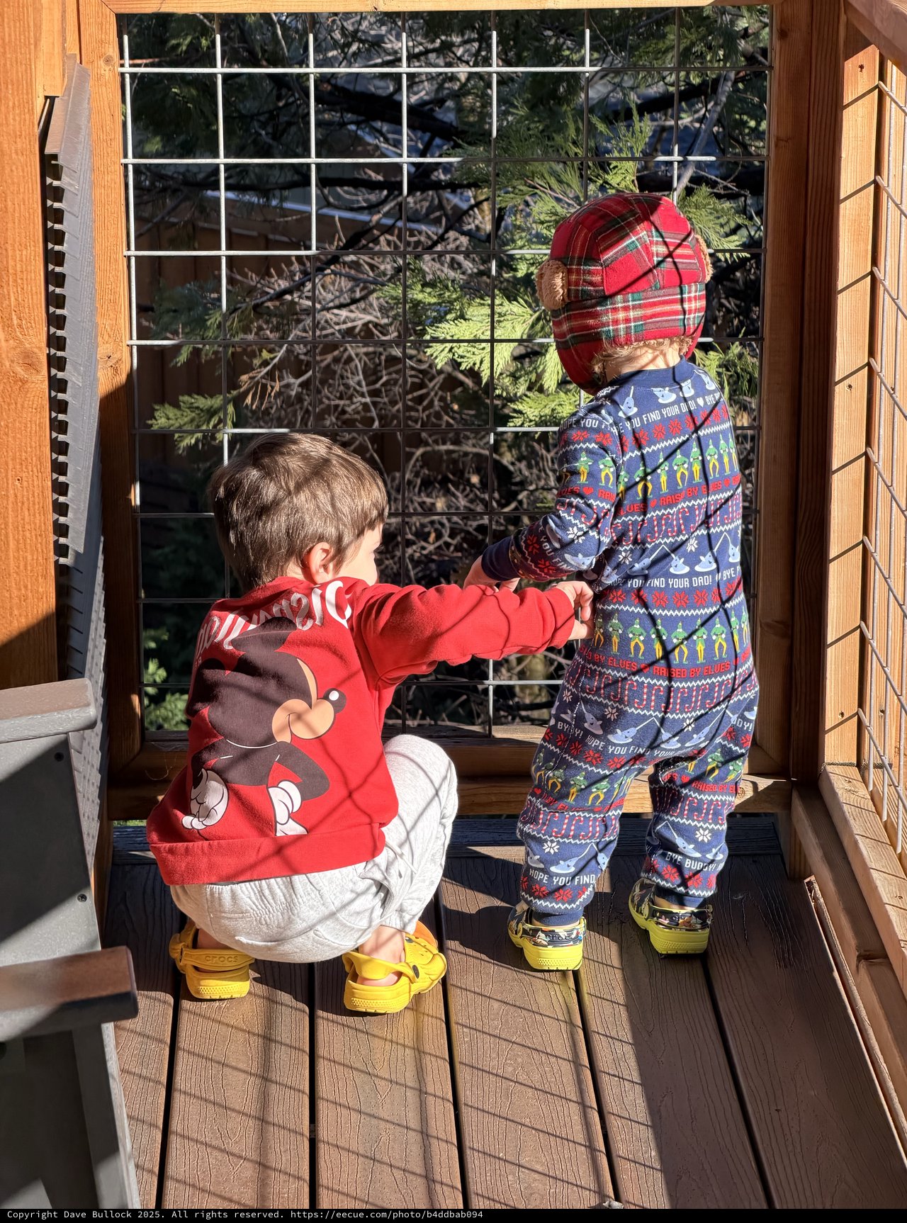Two Young Children Exploring Deck in Holiday Outfits