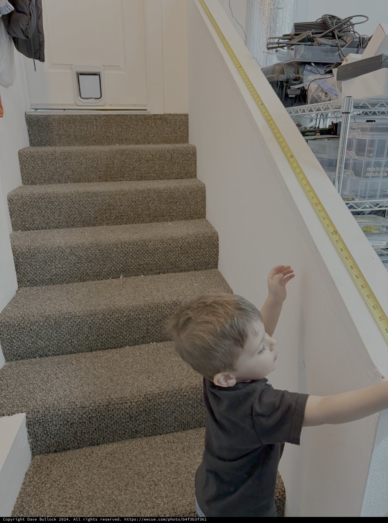 Young Child Measuring Staircase Handrail with Tape Measure