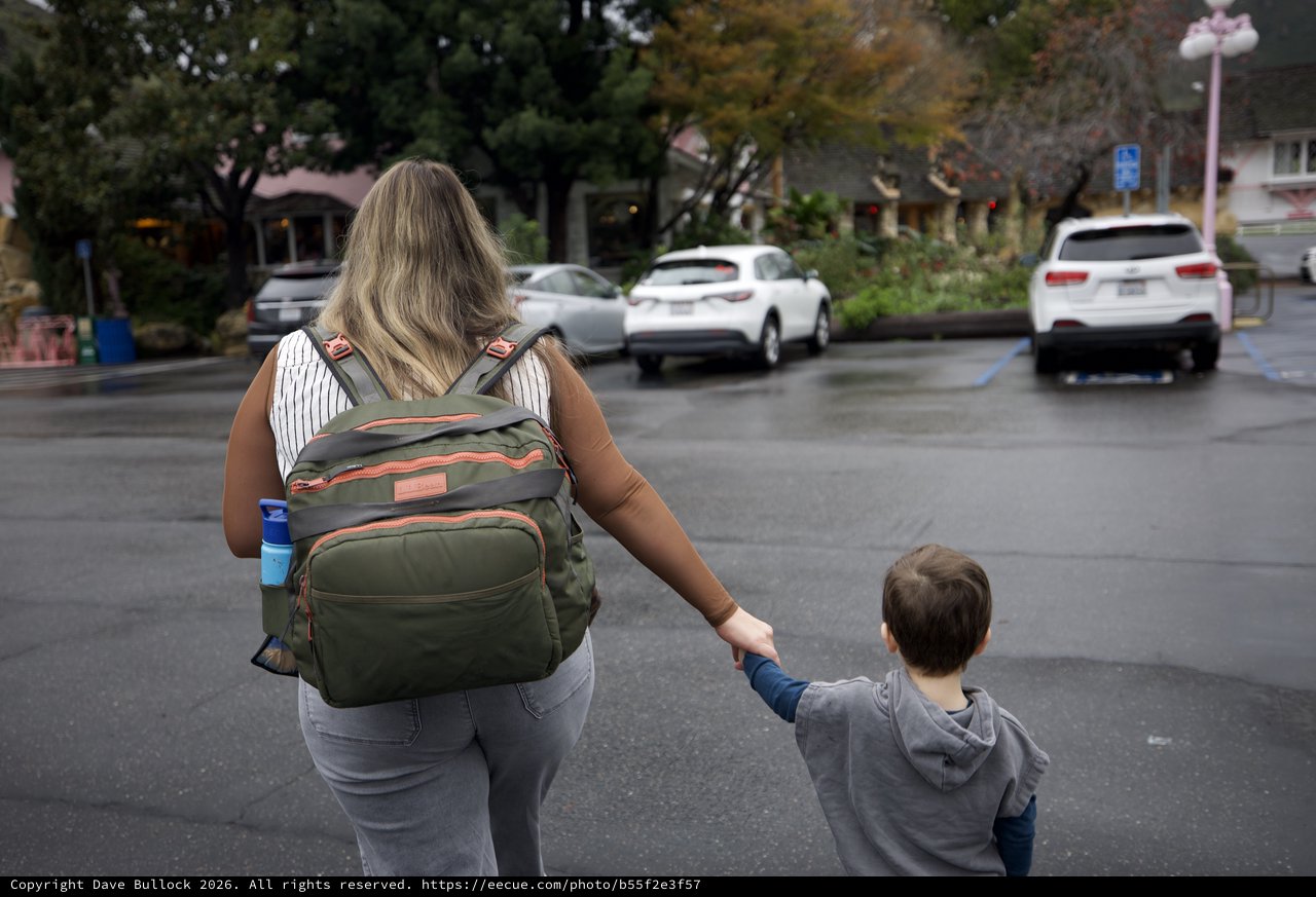Mother and Child Crossing Parking Lot at Dusk