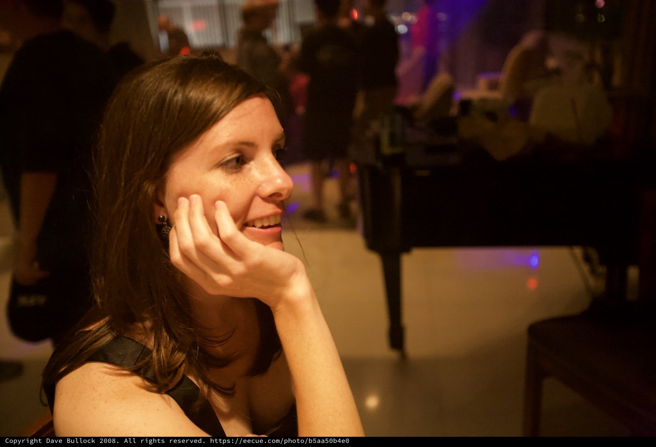 Smiling Woman Lost in Thought at Evening Venue