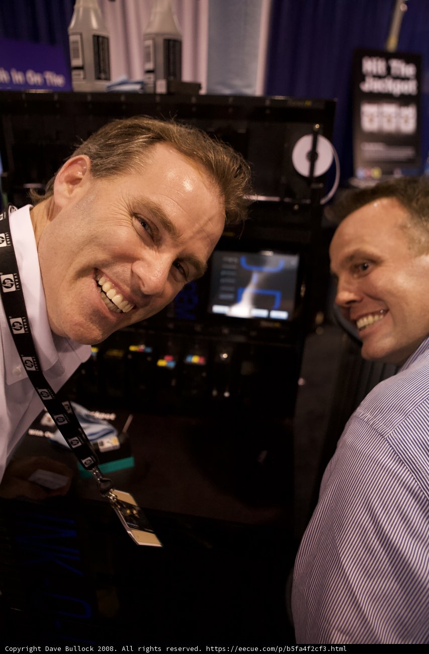 Two Men in High Spirits Next to a Monitor