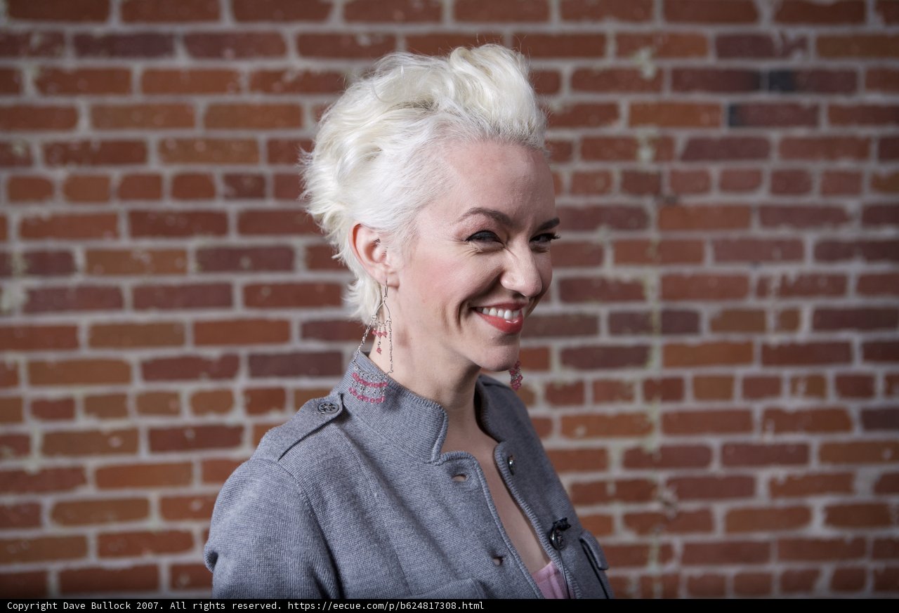 Smiling Lady in Front of Brick Wall
