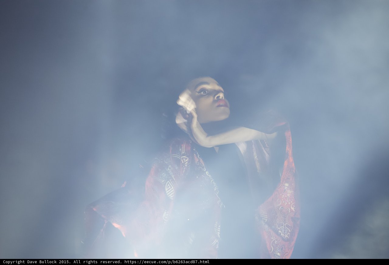 FKA twigs Looking Upward Heavy Haze Face Illuminated Red Brocade Kimono Elegant Hands Otherworldly