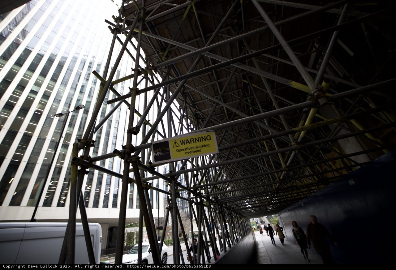 Urban Scaffolding Tunnel with Overhead Warning Sign