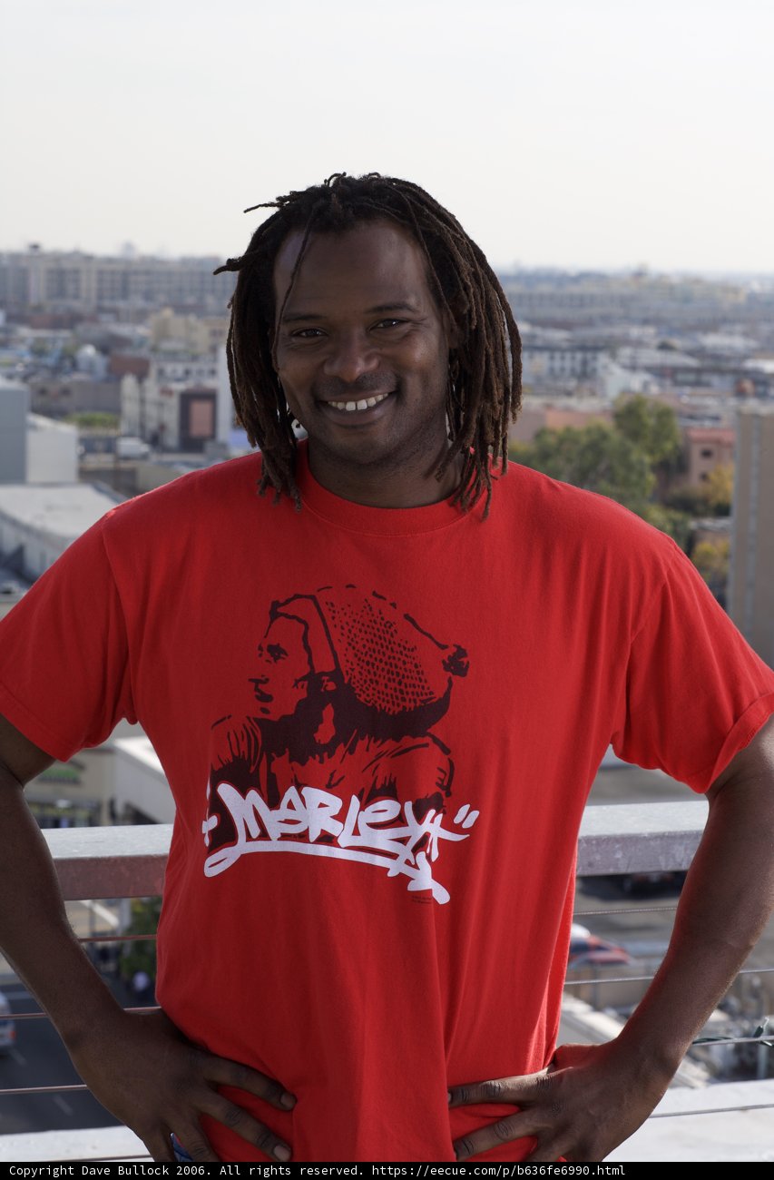 Red-Shirted Man Poses in Urban Landscape