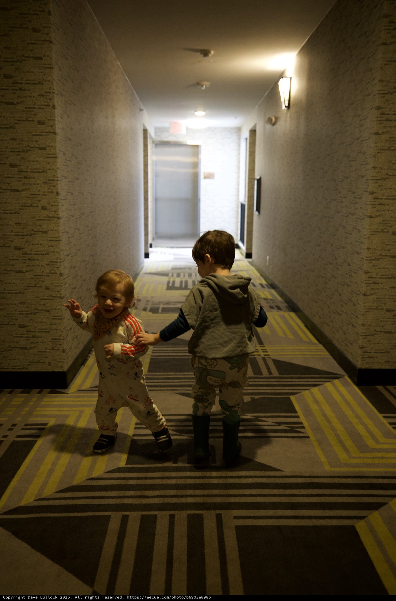 Two Young Children Playing in Hotel Corridor