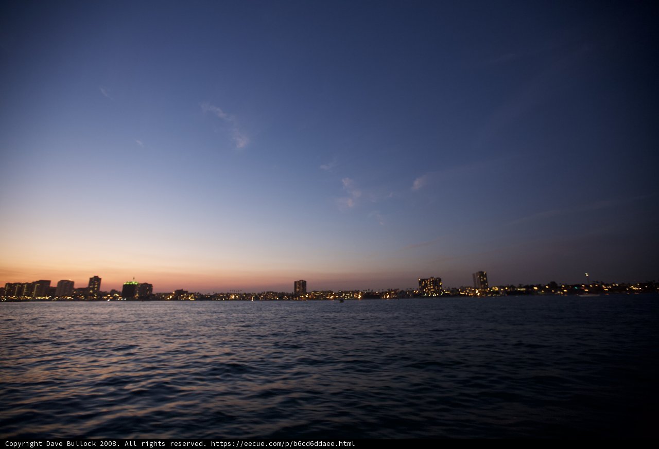 Sun sets over urban skyline from the water