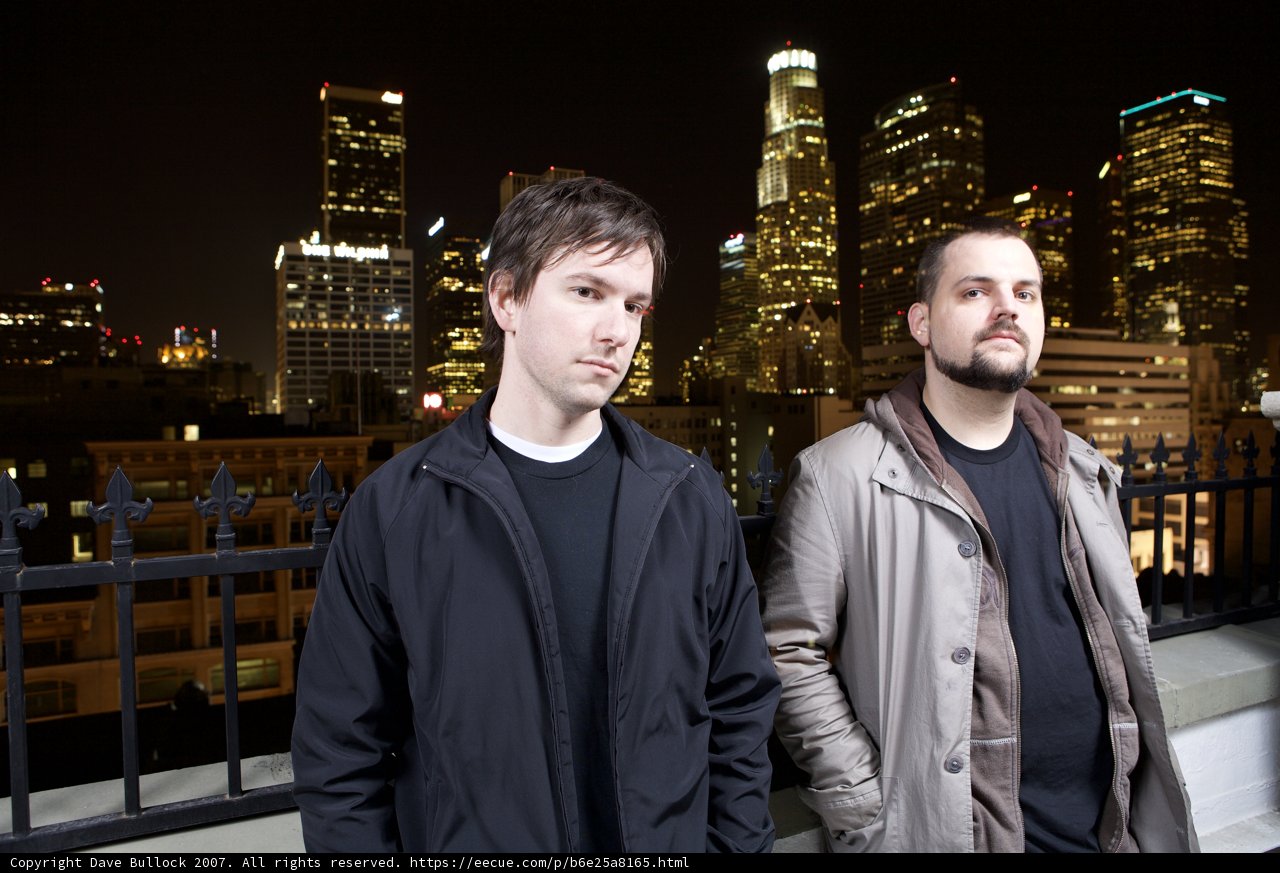 Two Men Standing in Front of a Cityscape