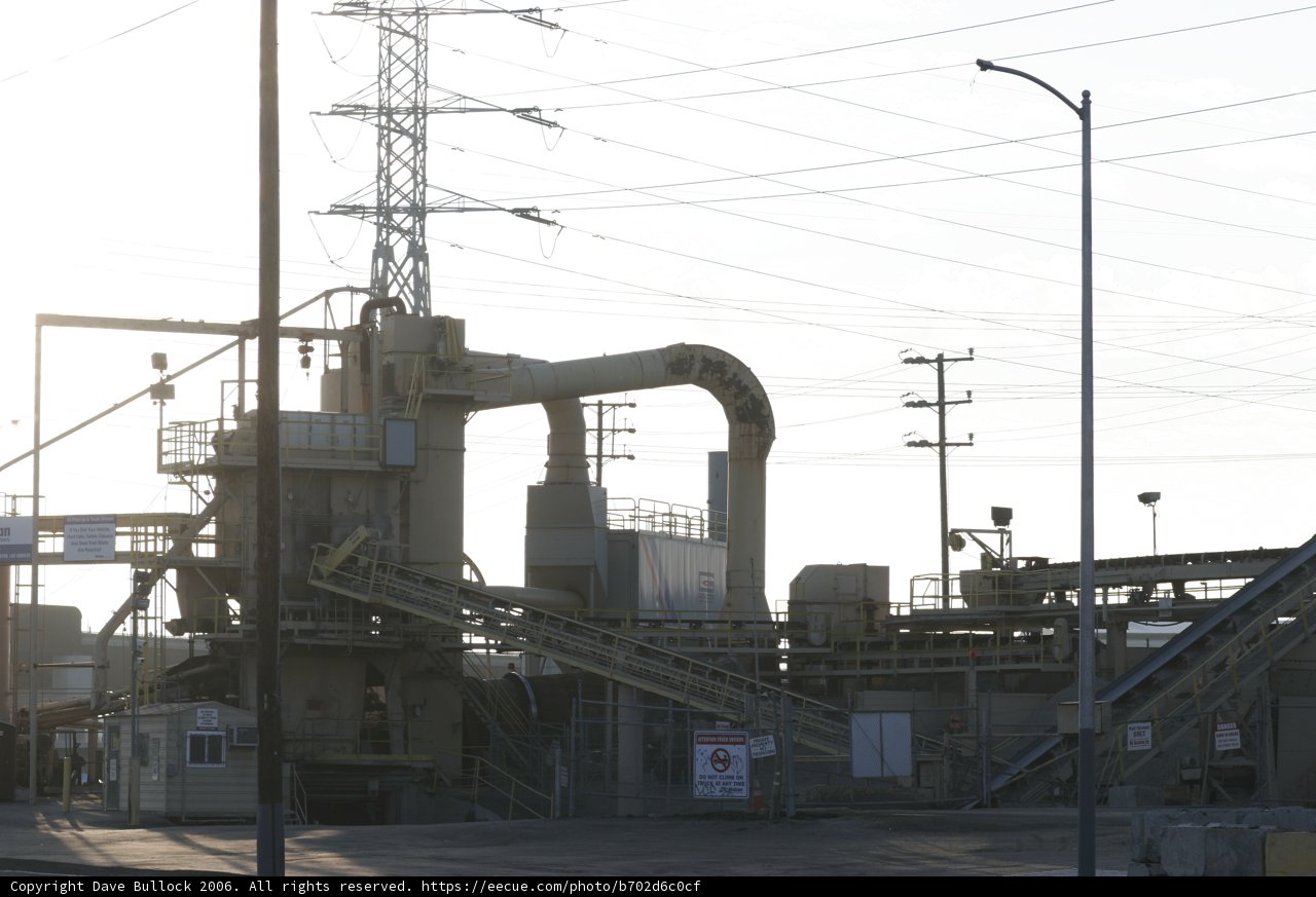 Towering Factory Amidst Power Lines