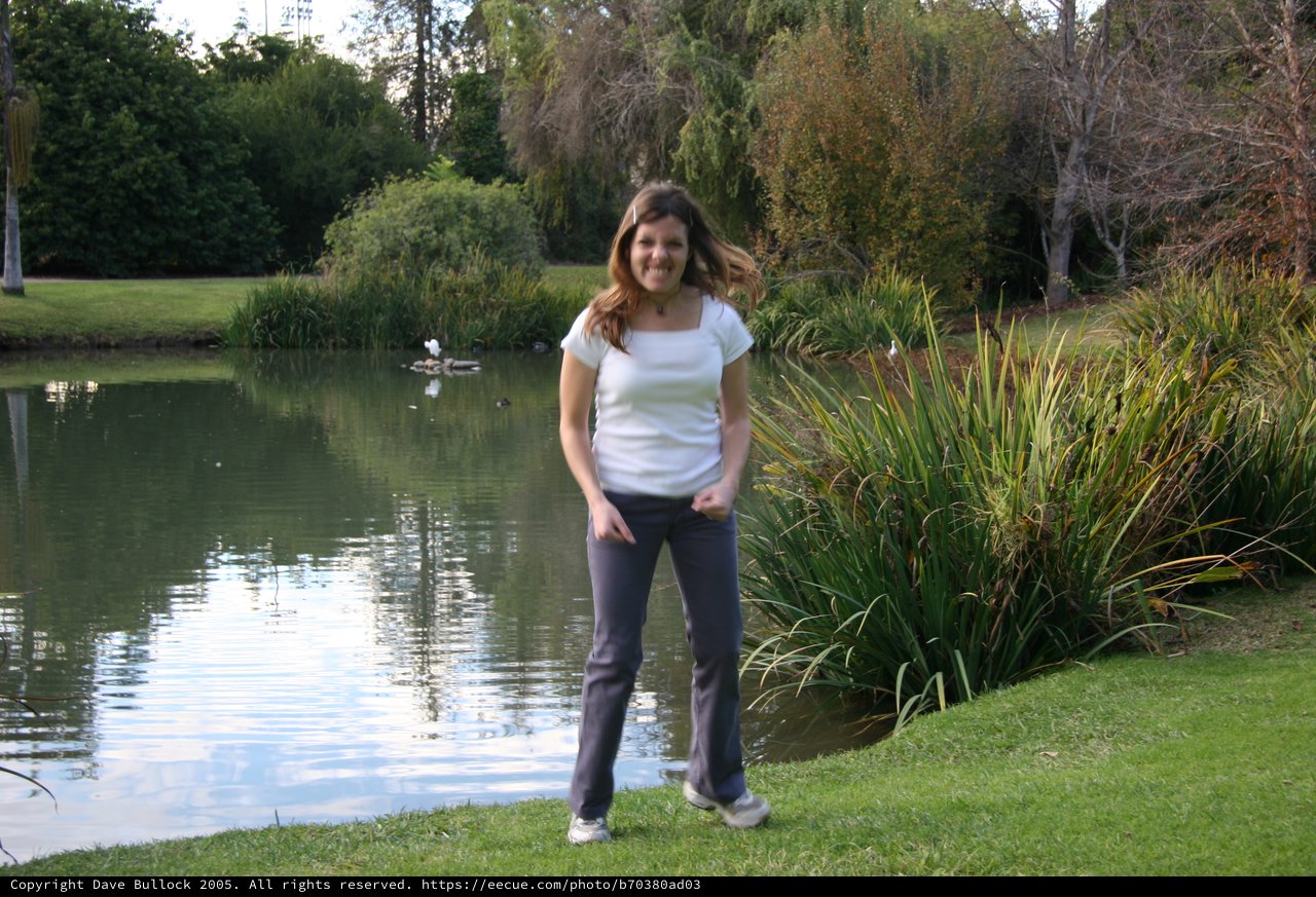 Woman Smiling by a Tranquil Park Pond