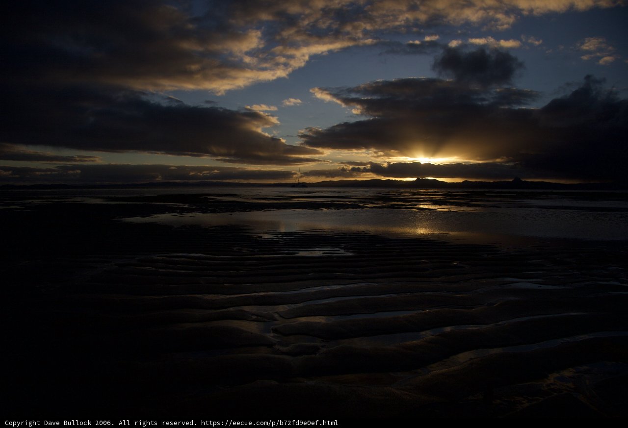Silhouette of a sunset over the sea at low tide