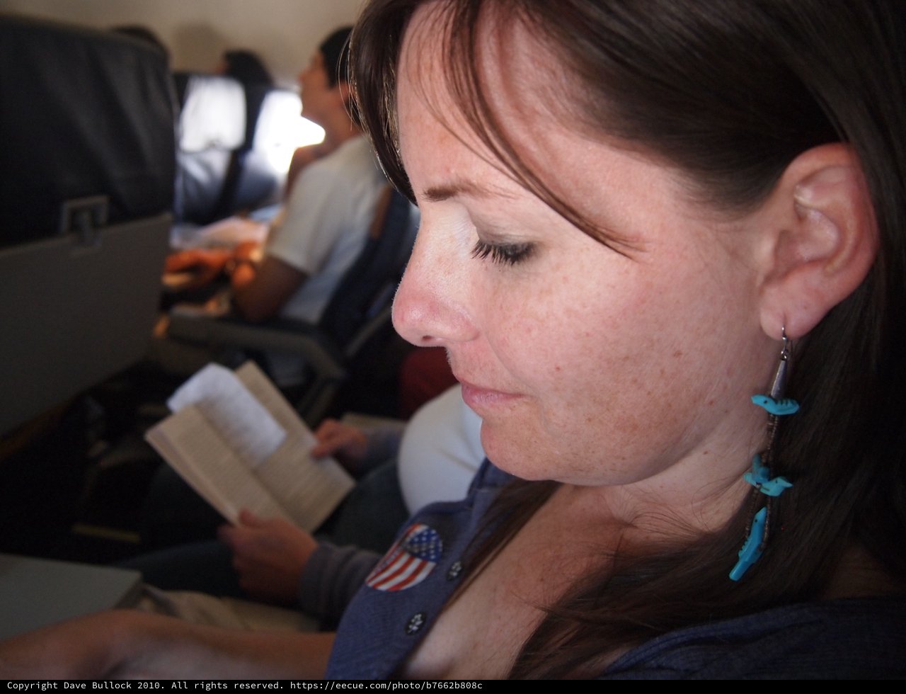 Quiet Reflection: Woman Reading Aboard a Flight