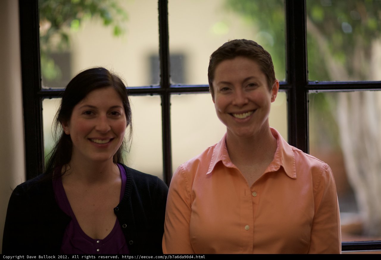 Two Women in Linen Blouses Smiling by the Window