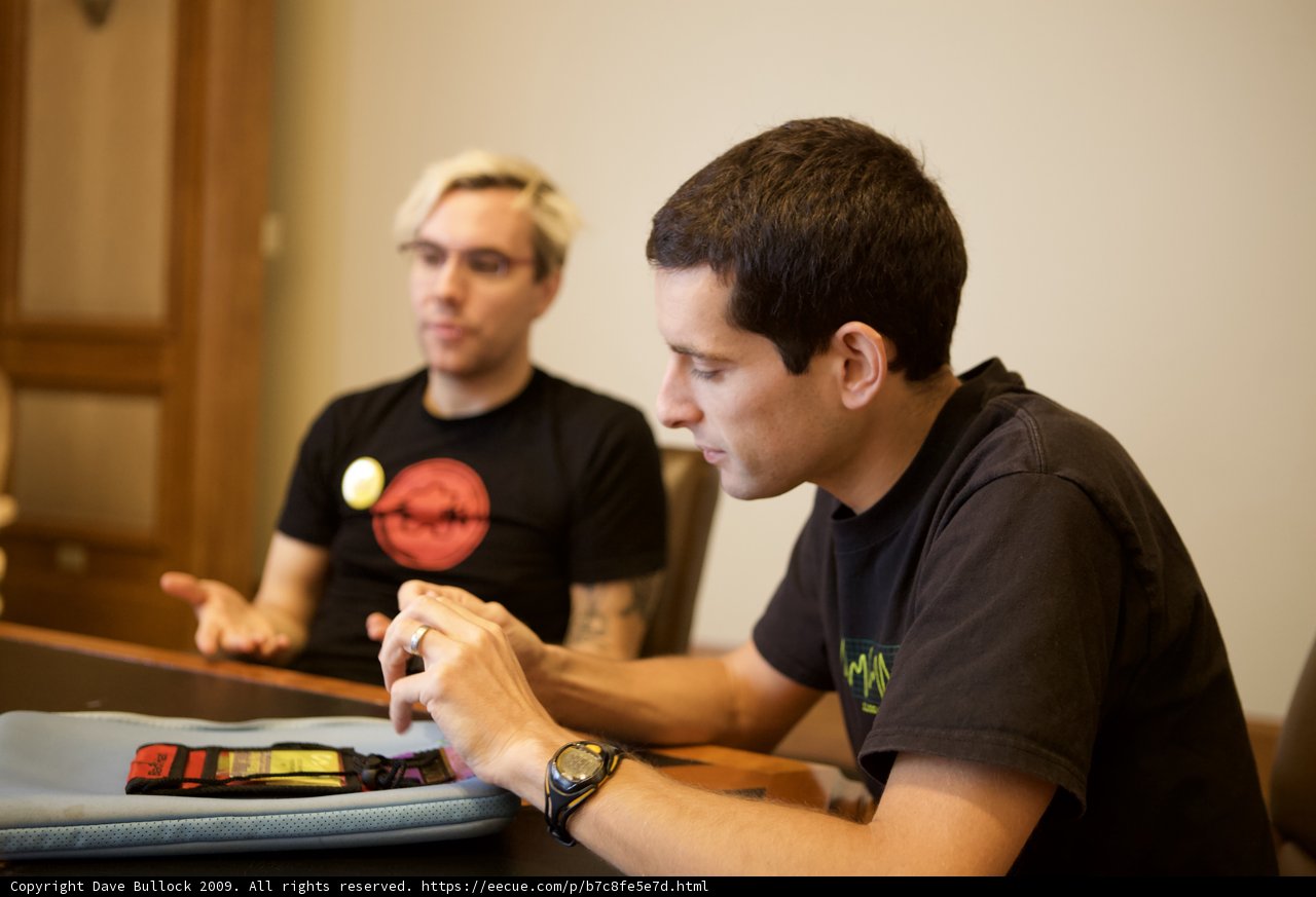 Two Men Discussing with a Tennis Ball on the Table